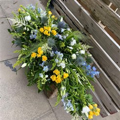 Blue and yellow casket spray 